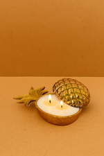 Load image into Gallery viewer, Gold pineapple-shaped candle holder with two lit candles on a brown background